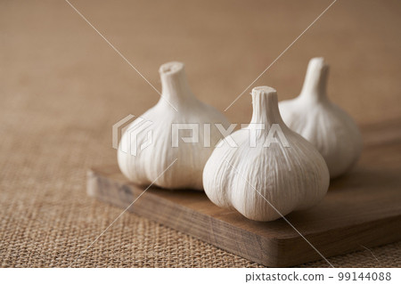 garlic on a wooden cutting board 99144088