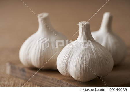 garlic on a wooden cutting board 99144089