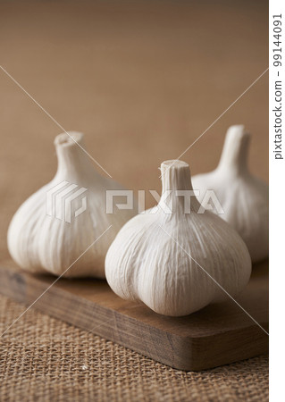 garlic on a wooden cutting board 99144091