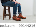 一個穿靴子的男人坐在椅子上 1 99144216