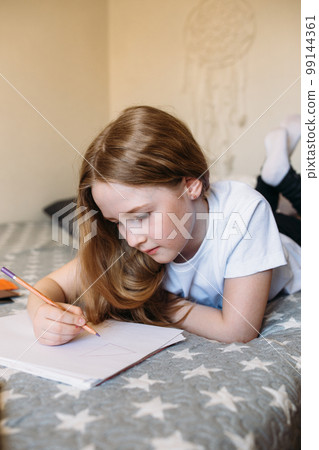 The girl after school plays at home, draws with pencils and felt-tip pens The girl after school plays at home, draws with pencils and felt-tip pens 99144361