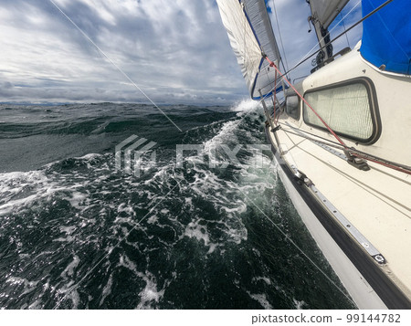 Sailboat against storm and waves in open sea. concept of uncertain future, suspense and peradventure Sailboat against storm and waves in open sea. concept of uncertain future, suspense and peradventure 99144782