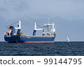 Huge cargo ship and small sailboat in the open sea. Concept of difference, diversity and distinction 99144795