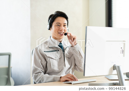 Young male engineer having a web conference in the office Young male engineer having a web conference in the office 99144826