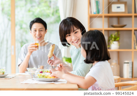 family having breakfast in the living room family having breakfast in the living room 99145024