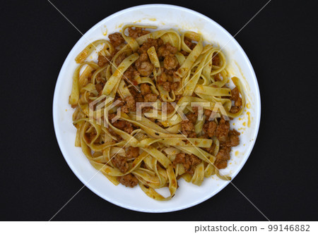 Italian pasta on a white plate. Meat and pasta with tomatoes. 99146882