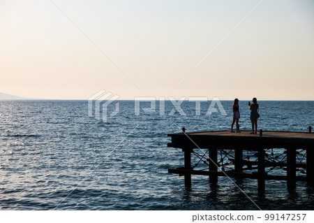 Silhouettes of people on a derelict pier Silhouettes of people on a derelict pier 99147257