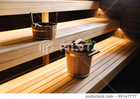 Modern interior of wooden spa cabin. View of empty Finnish sauna room with dry steam. New and fresh 99147777