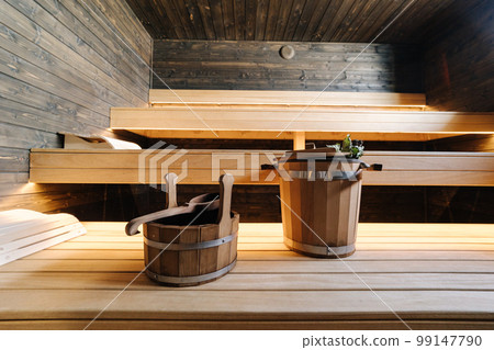 Modern interior of wooden spa cabin. View of empty Finnish sauna room with dry steam. New and fresh Modern interior of wooden spa cabin. View of empty Finnish sauna room with dry steam. New and fresh 99147790