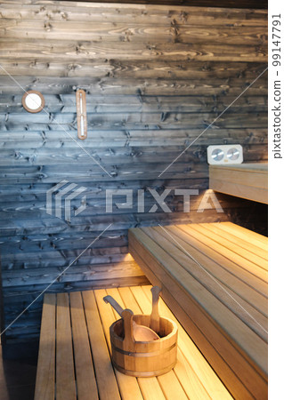Interior of Finnish sauna. Front view of classic wooden sauna. Relax in hot sauna with dry steam Interior of Finnish sauna. Front view of classic wooden sauna. Relax in hot sauna with dry steam 99147791