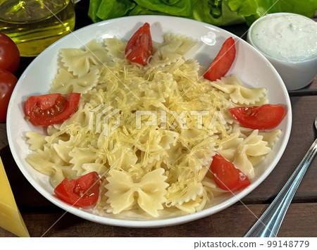 Pasta bows with tomatoes and parmesan cheese 99148779