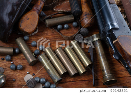 Antique 16-gauge break-action smooth-bored shotgun with brass cases and accessories for cartridge reloading. Antique 16-gauge break-action smooth-bored shotgun with brass cases and accessories for cartridge reloading. 99148861