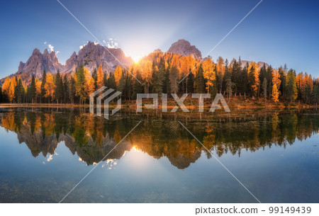 Lake with reflection in water and orange trees at sunrise Lake with reflection in water and orange trees at sunrise 99149439