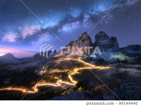 Milky Way, car light trails on mountain road at starry night Milky Way, car light trails on mountain road at starry night 99149440