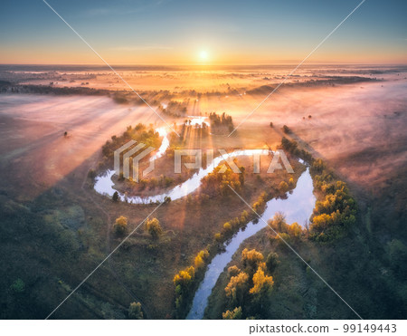 Aerial view of curving river in pink low clouds at sunrise 99149443