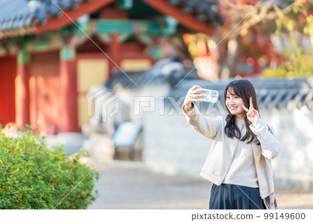 旅行時用智能手機自拍的女性 99149600