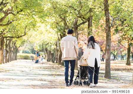 Young family taking a walk with a stroller 99149616