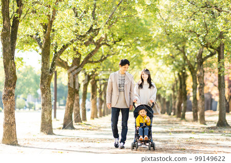 Young family taking a walk with a stroller 99149622