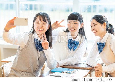 High school girl taking a selfie with a smartphone 99149837