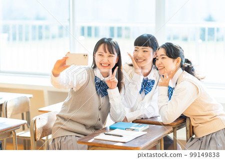 High school girl taking a selfie with a smartphone High school girl taking a selfie with a smartphone 99149838