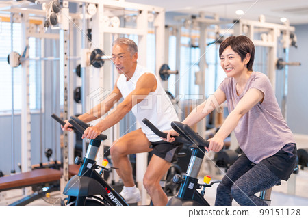 一對中年夫婦在體育俱樂部騎健身車 99151128