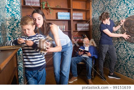 Friendly family is trying to find a solution to the puzzle in the quest room 99151639