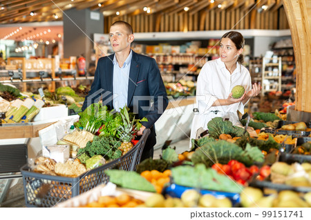 Couple shopping at vegetables department at supermarket 99151741