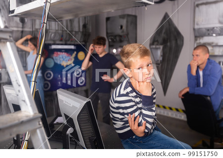 Close-knit family with children thinks, trying to find a solution to the puzzle in the quest room, to get out of there Close-knit family with children thinks, trying to find a solution to the puzzle in the quest room, to get out of there 99151750