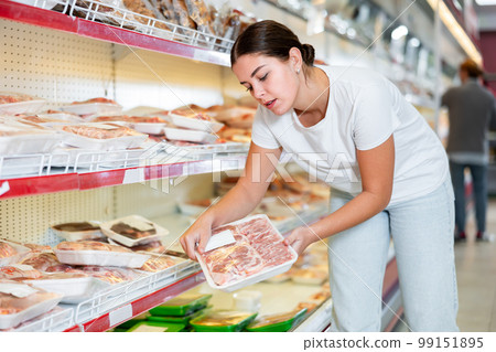 Woman looking for packaged mutton in grocery store Woman looking for packaged mutton in grocery store 99151895
