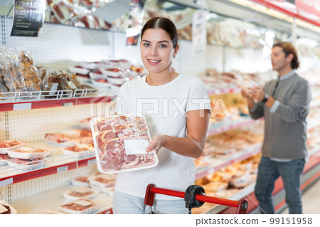 Female customer chooses meat for cooking steak in the meat department of supermarket Female customer chooses meat for cooking steak in the meat department of supermarket 99151958