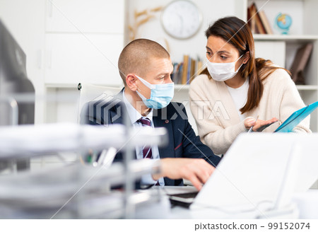 Business coworkers in fase masks discussing new ideas 99152074