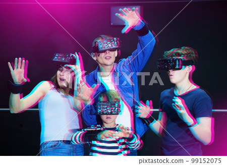 Cheerful family in virtual reality goggles playing games together Cheerful family in virtual reality goggles playing games together 99152075