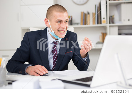 Male employee in face mask speak on web conference Male employee in face mask speak on web conference 99152194
