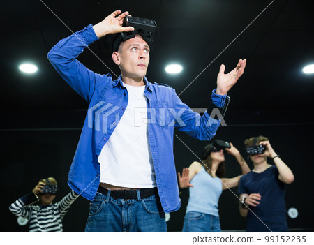 Young man in VR goggles experiencing virtual reality 99152235