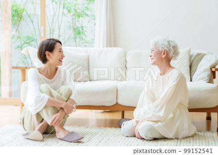 Mother and daughter relaxing in the living room Mother and daughter relaxing in the living room 99152541