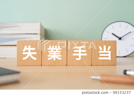 A desk with a block that says unemployment benefits 99153237