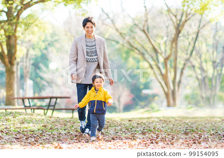 Dad and boy playing in the park 99154095