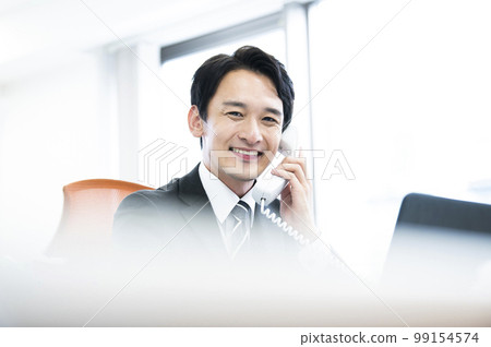Business phone call conversation smile male looking at camera Business phone call conversation smile male looking at camera 99154574
