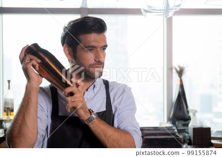 Young caucasian man is bartender holding and shaker for mixing beverage preparation serving. 99155874