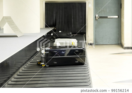 luggage on a belt at the airport terminal. 99156214