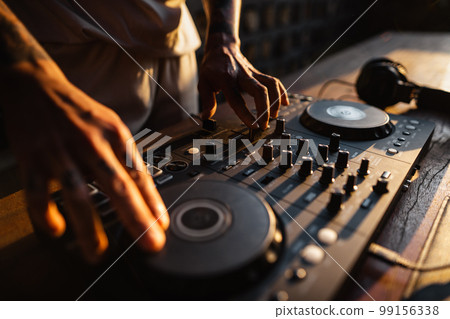 DJ playing music,Man using mixing desk at party out in the evening DJ playing music,Man using mixing desk at party out in the evening 99156338