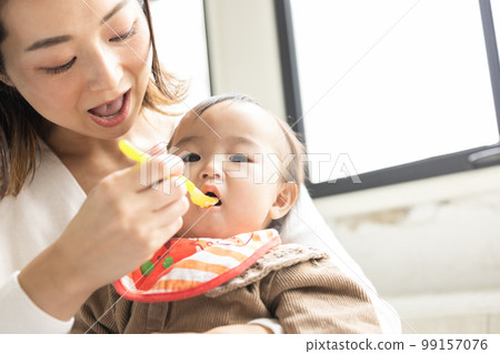 Baby eating baby food Baby eating baby food 99157076