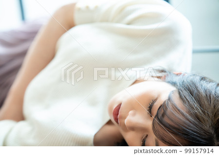 A woman lying down and relaxing A woman lying down and relaxing 99157914