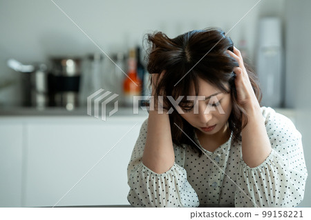 Middle-aged woman worried in the kitchen 99158221
