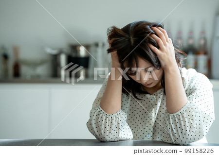 Middle-aged woman worried in the kitchen 99158226