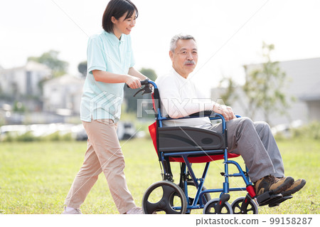 照顧者和老人/老人和助手走在輪椅上 99158287