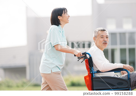 照顧者和老人/老人和助手走在輪椅上 99158288