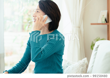 Middle woman talking in the living room Middle woman talking in the living room 99158480