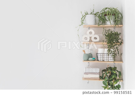 Beautiful white bathroom. Wooden shelves. Rolled towels, stacked towels and baskets. Soap, washcloth 99158581