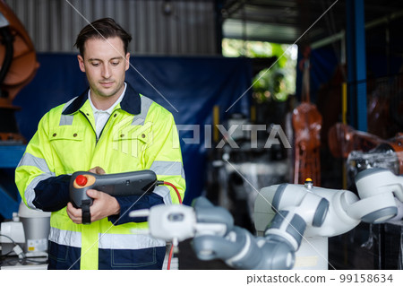 man engineer using remote robot controller operate standing at automation robot arms machine. man engineer using remote robot controller operate standing at automation robot arms machine. 99158634
